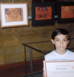 one of the young artists holding his certificate